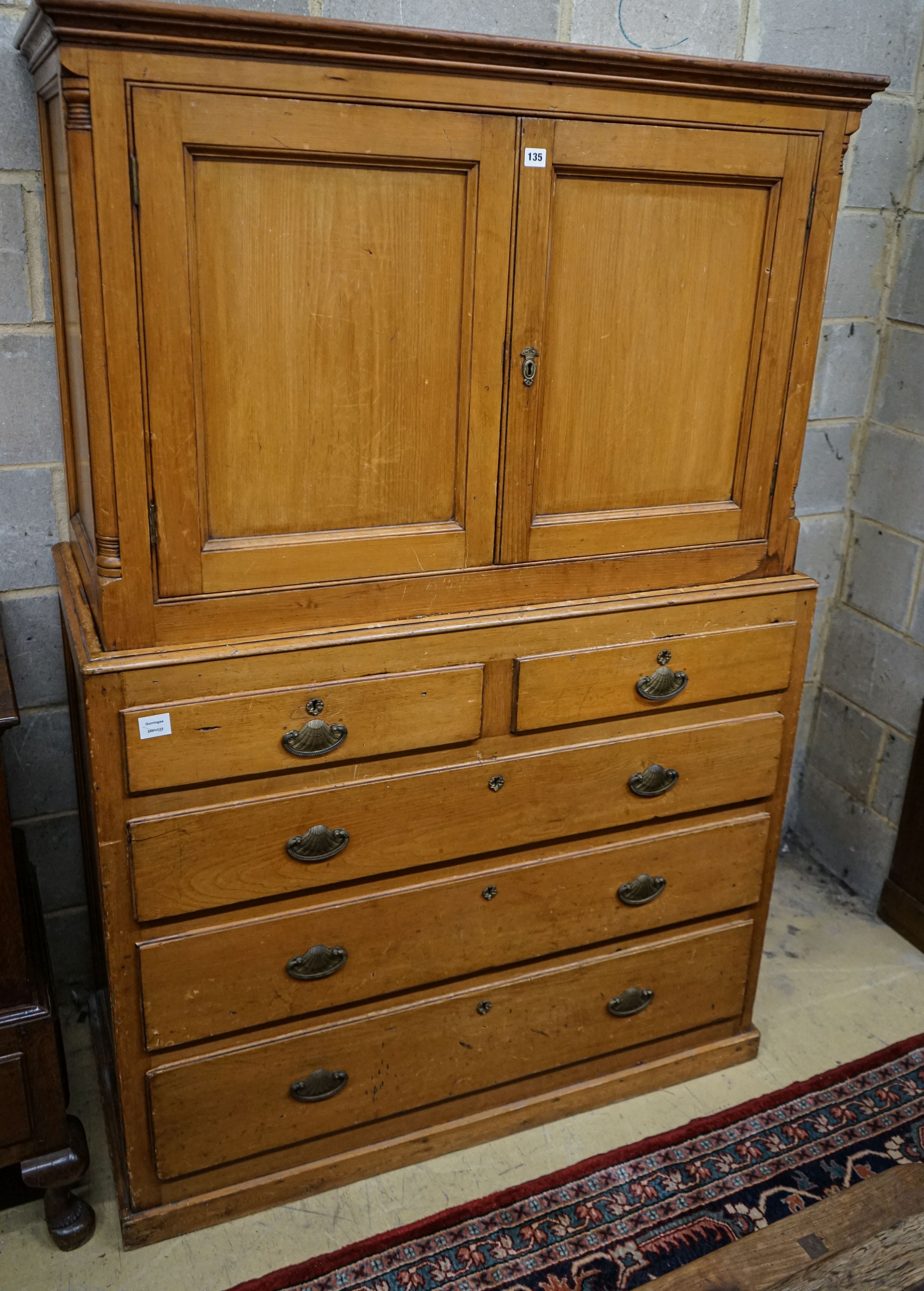 An early Victorian pine kitchen cabinet, with two panelled doors over two short and three long drawers, on plinth foot, width 118cm, depth 55cm, height 179cm